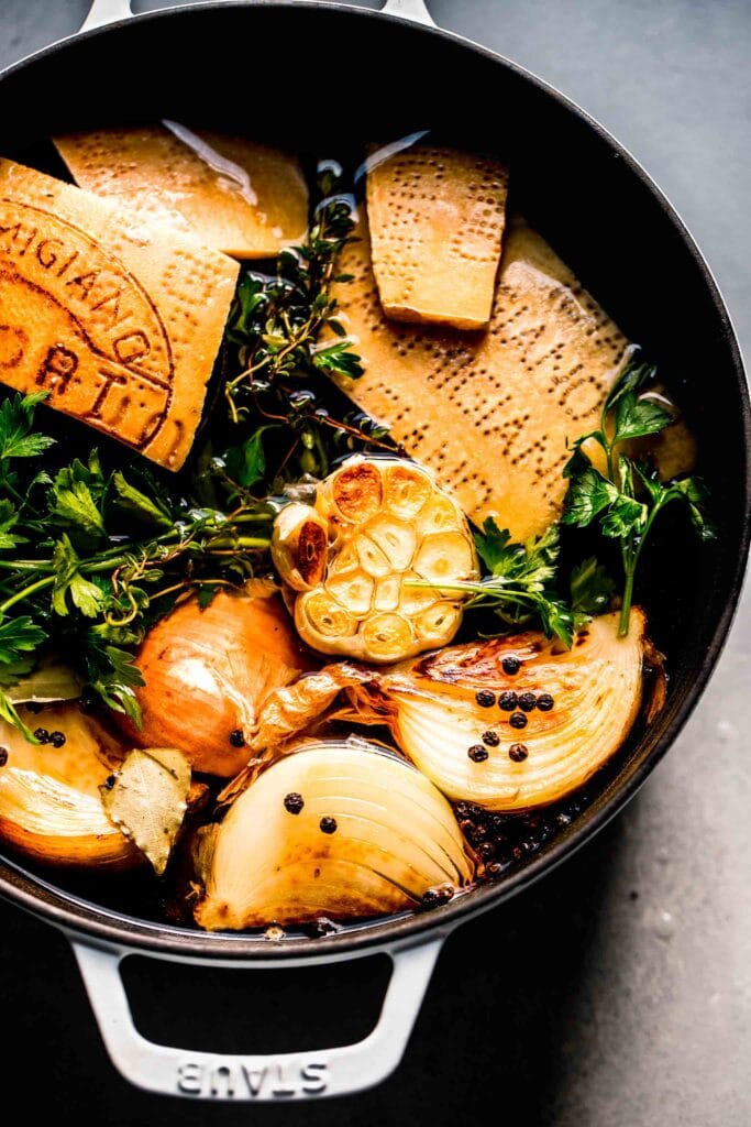 INGREDIENTS FOR PARMESAN BROTH IN STOCK POT WITH WATER.