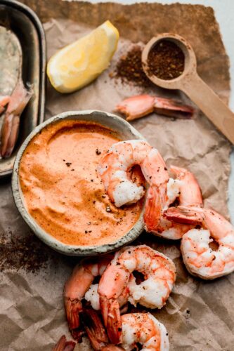 Overhead shot of remoulade in bowl with shrimp surrounding it.