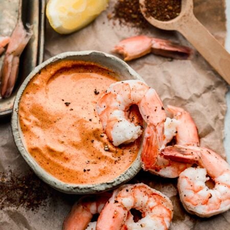Overhead shot of remoulade in bowl with shrimp surrounding it.