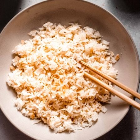 Overhead shot of bowl of coconut rice with chopsticks.