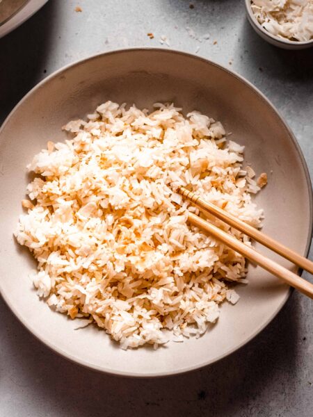 Overhead shot of bowl of coconut rice with chopsticks.
