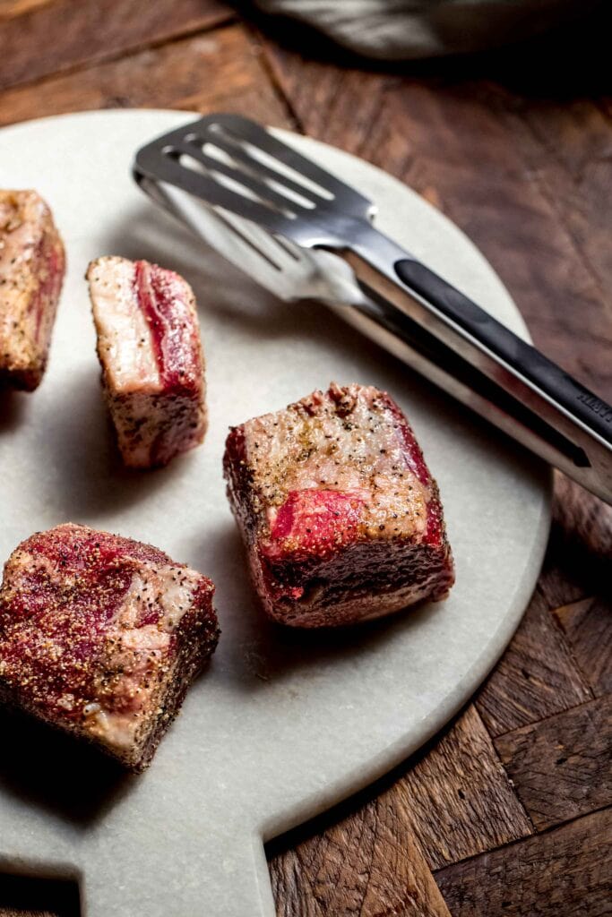 Seasoned short ribs on cutting board.