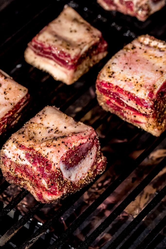 Short ribs on grate of smoker.