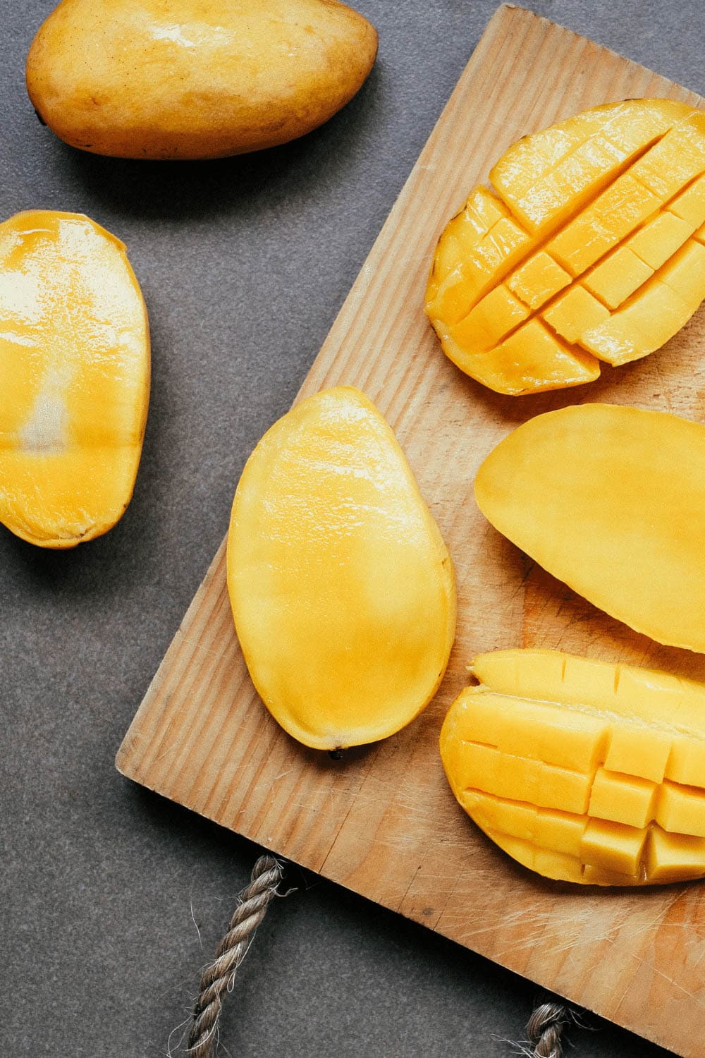 Cut mangoes on cutting board. 