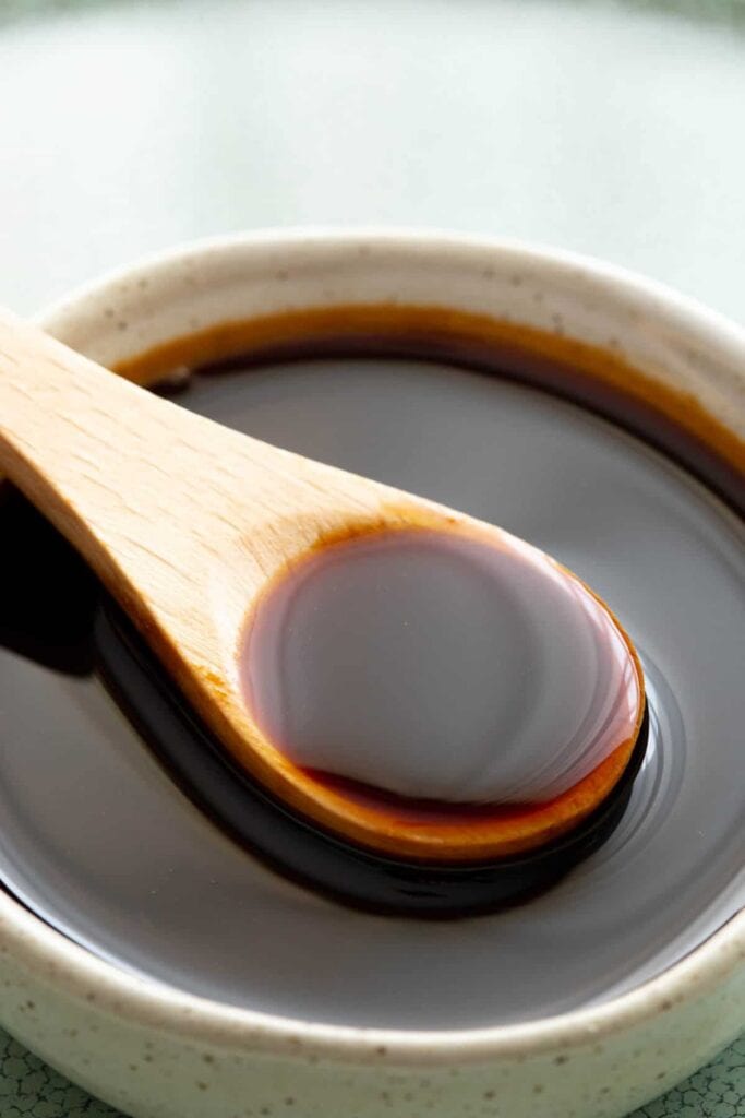 Bowl of unagi sauce with spoon for sushi.