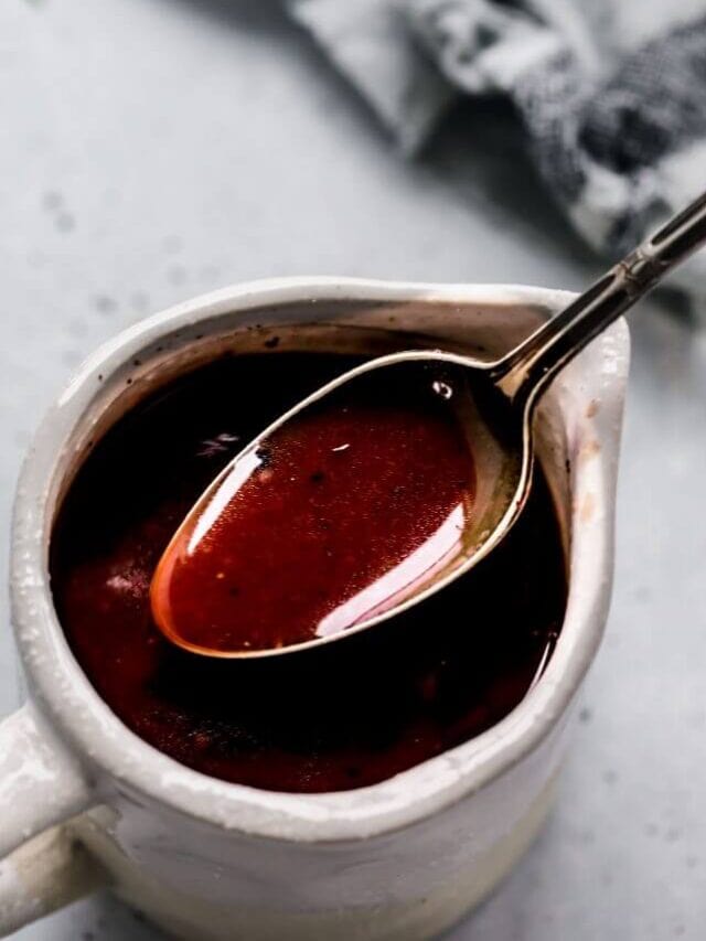 Red wine sauce in small serving container with spoon.