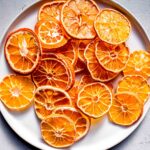 Dried orange slices on small white plate.