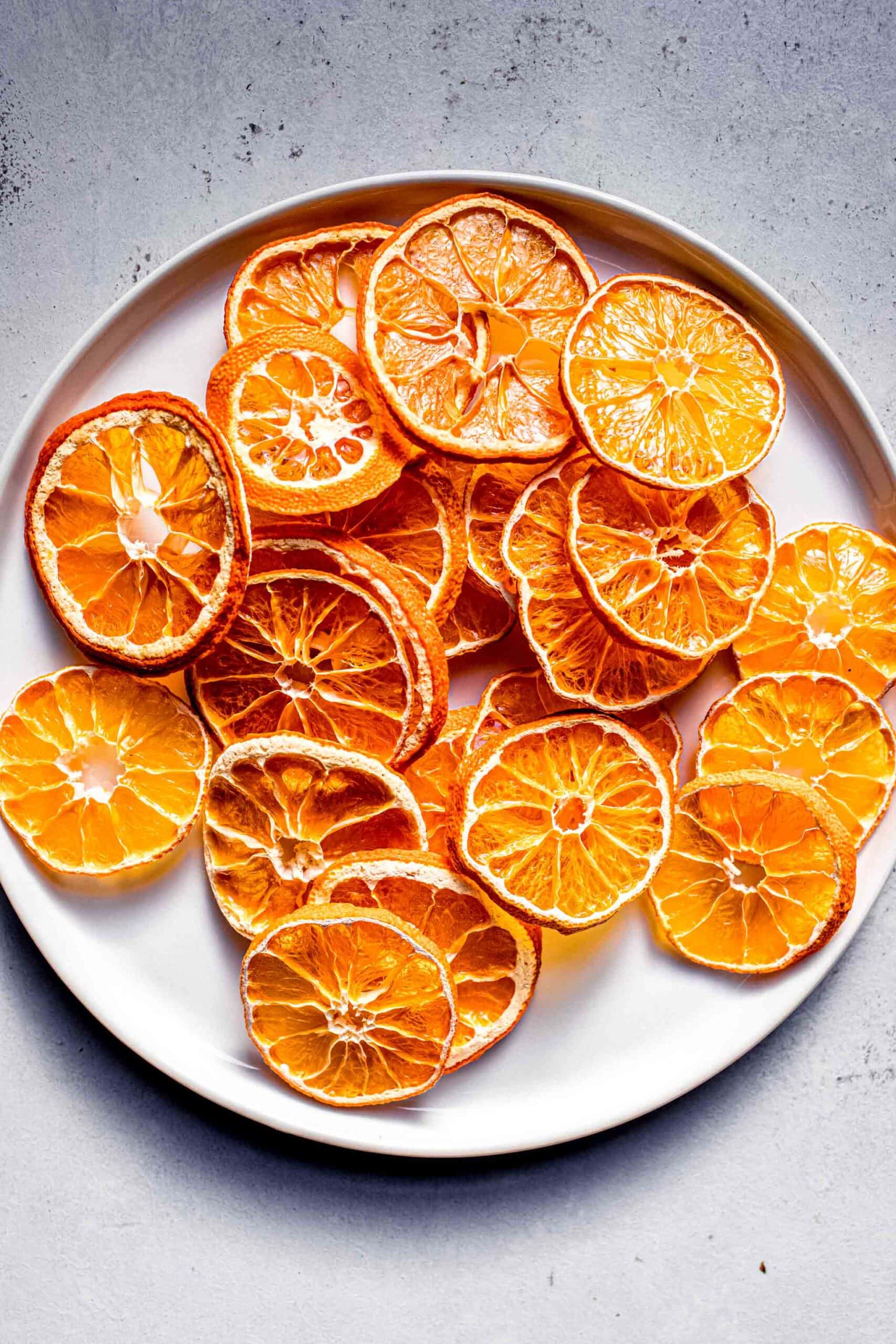 Dried orange slices on small white plate.