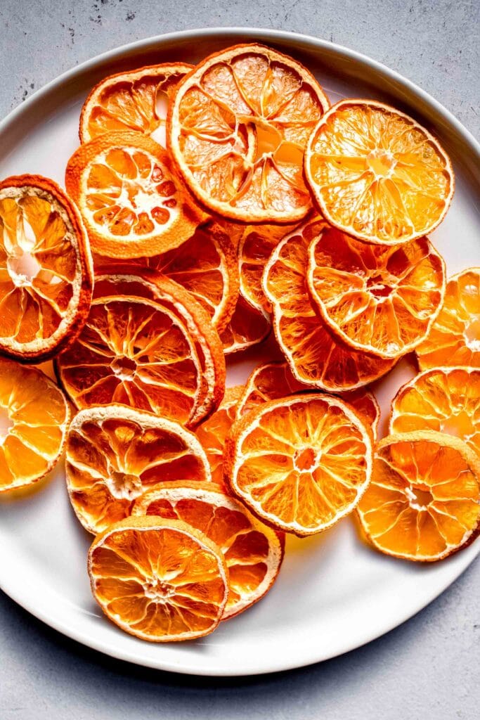 Dried orange slices on small white plate.