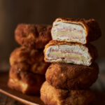 Chicken cordon bleu stacked on cutting board.