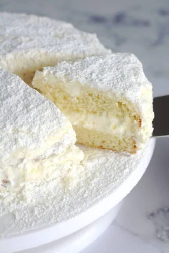Italian lemon cream cake being sliced into.