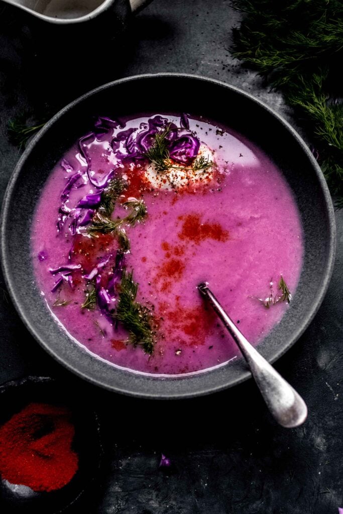 Bowl of red cabbage soup sprinkled with vibrant red paprika. 