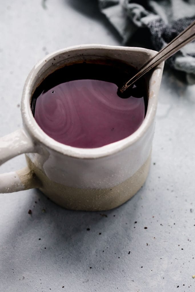 Side view of small cruet with red wine sauce. 