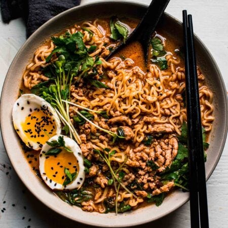 Overhead shot of tan tan noodles in bowl with black chopsticks.