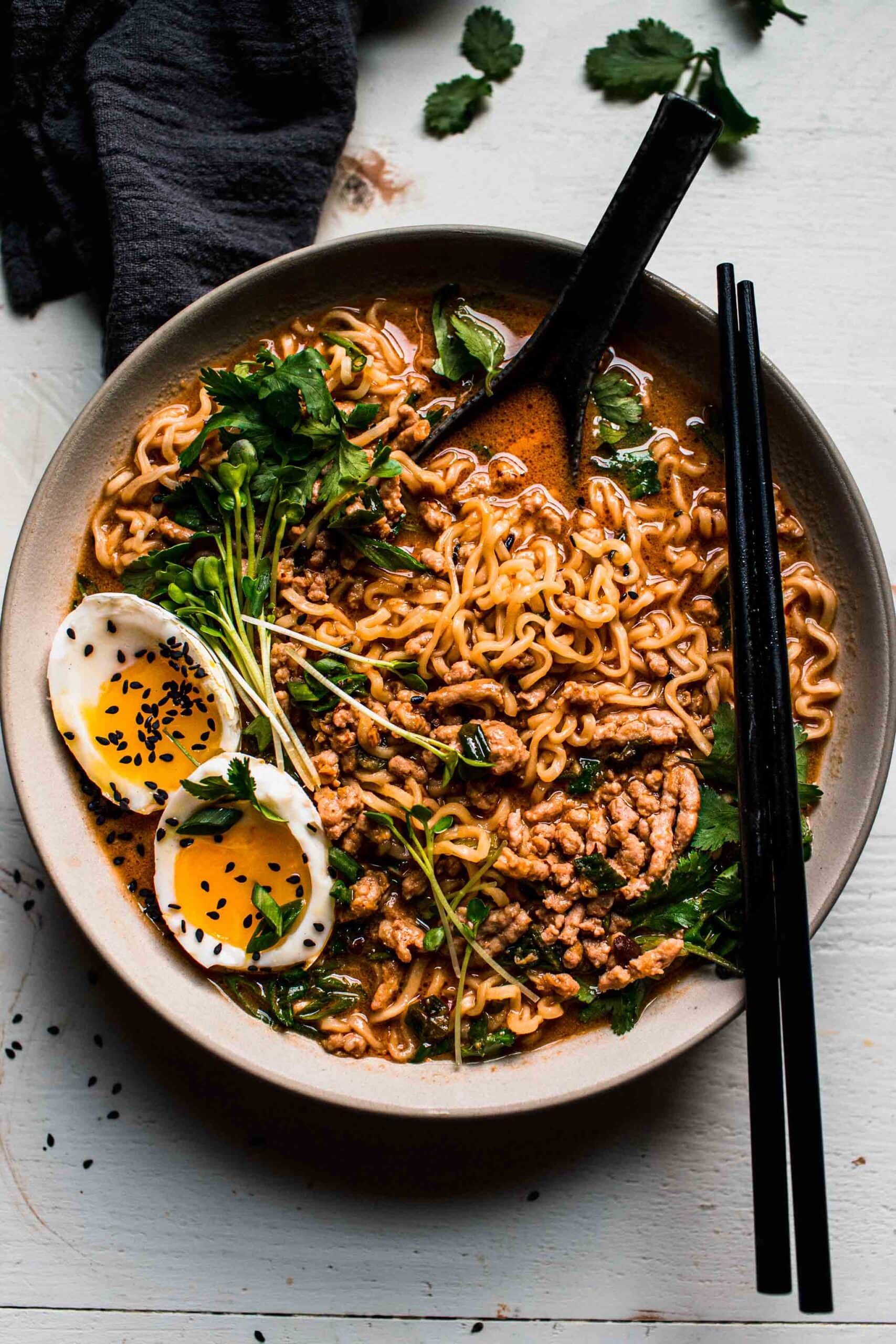 Overhead shot of tan tan noodles in bowl with black chopsticks.