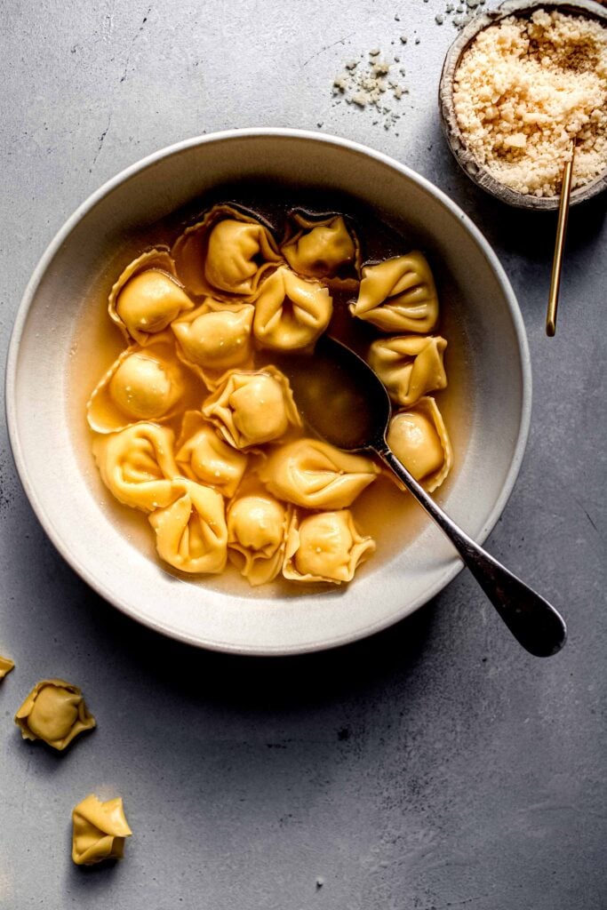 Overhead shot of tortellini en brodo in bowl with spoon.