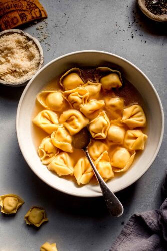 Overhead shot of tortellini en brodo in bowl with spoon.