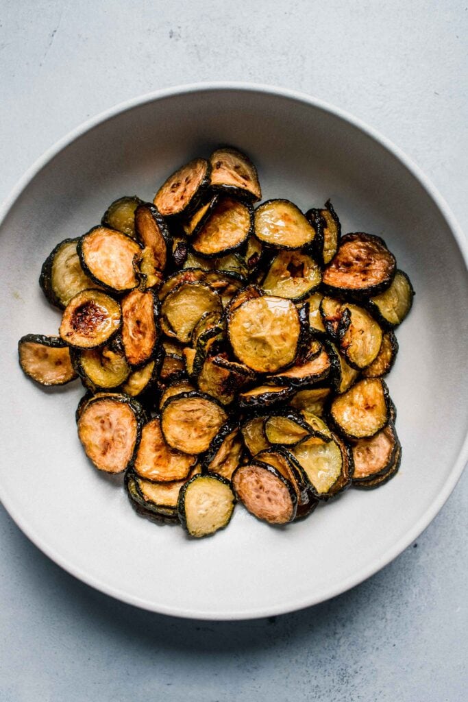 Fried zucchini slices in bowl.