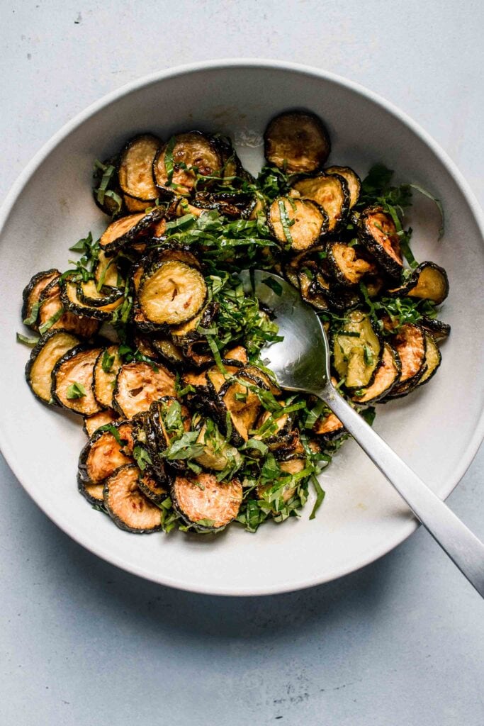 Zucchini tossed with basil in bowl.