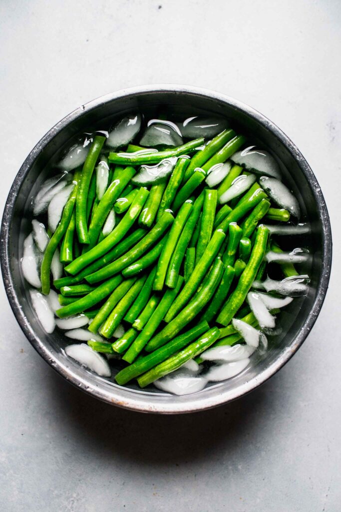 Blanched green beans in ice water bath.