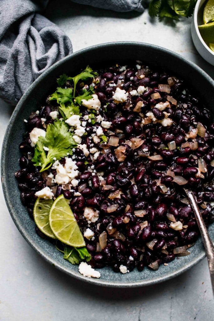 Overhead close up of Mexican black beans in grey bowl. 