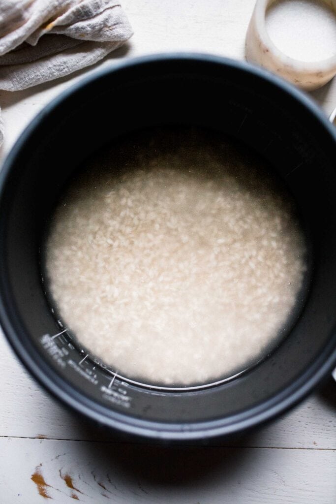 Rice and water in rice cooker liner. 