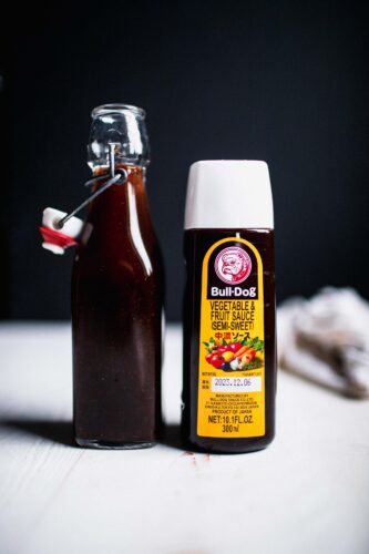 Bottle of homemade tonkatsu sauce next to bottle of bull dog sauce.