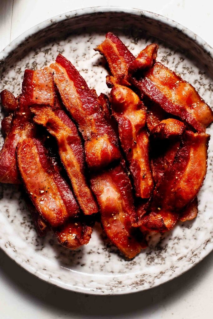 Crispy bacon strips on plate. 