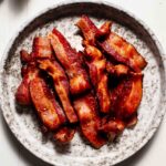 Crispy bacon strips on plate.