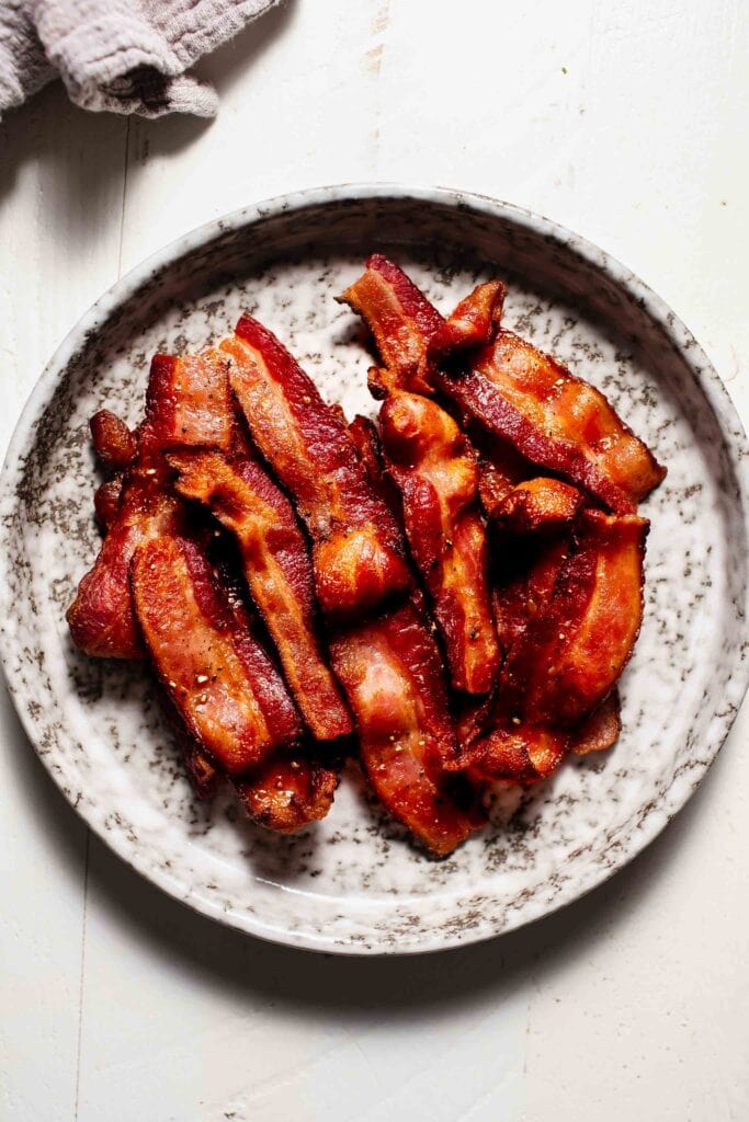 Crispy bacon strips on plate.