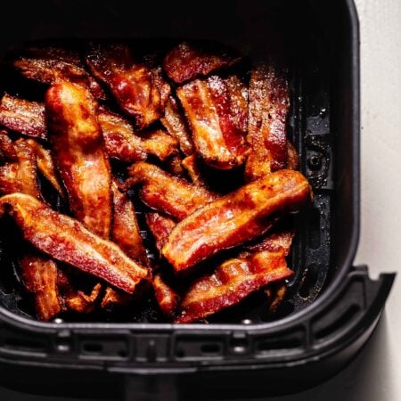 Crispy bacon in air fryer basket.