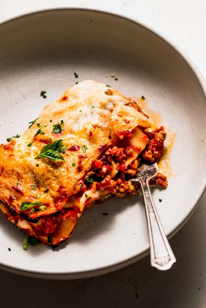 Lasagna in serving dish with fork. 