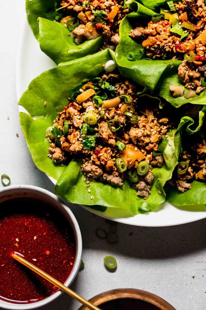 Overhead close up of lettuce wraps arranged on serving plate.