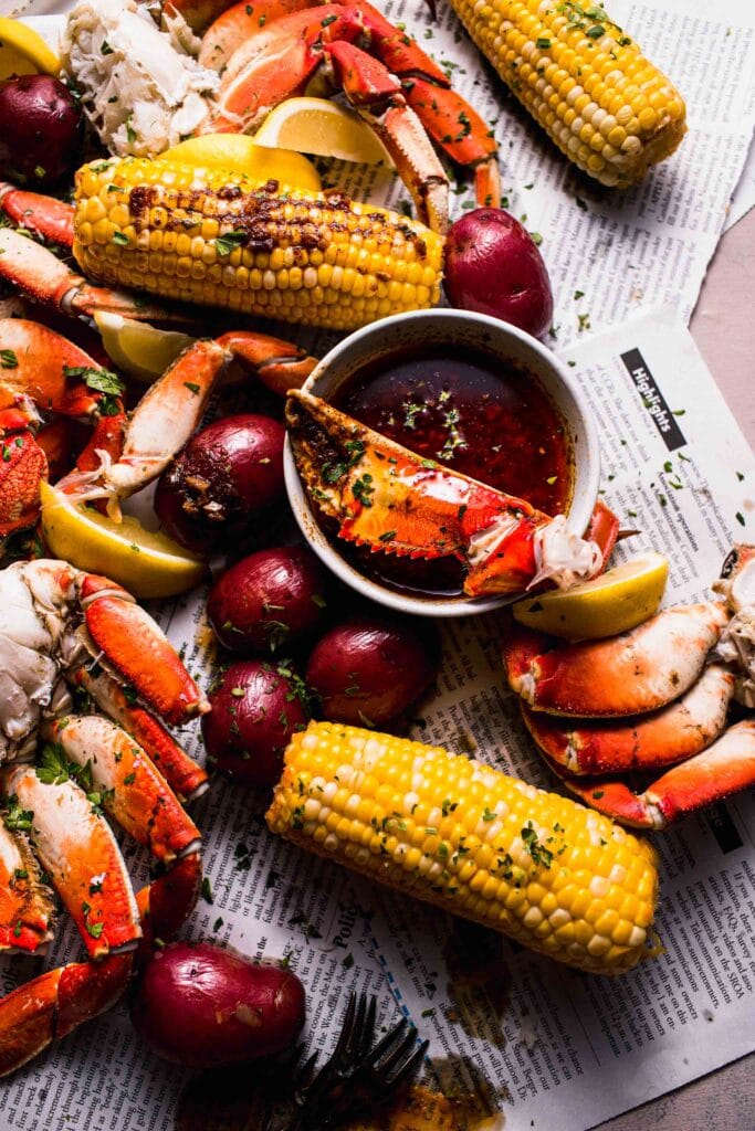 Seafood boil spread out on newspapers with Whole Sha-Bang Sauce.