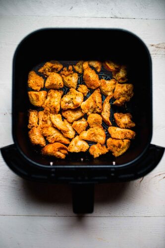 Croutons in air fryer basket.