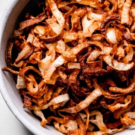 Crispy air fryer onions in white bowl.