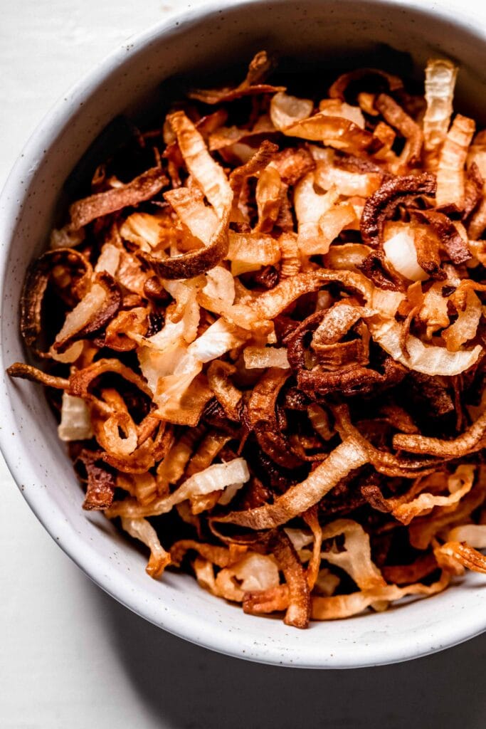 Crispy air fryer onions in white bowl.