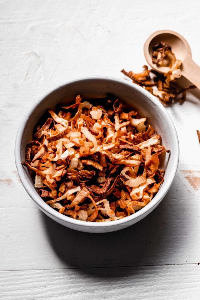 Crispy air fryer onions in small white bowl. 