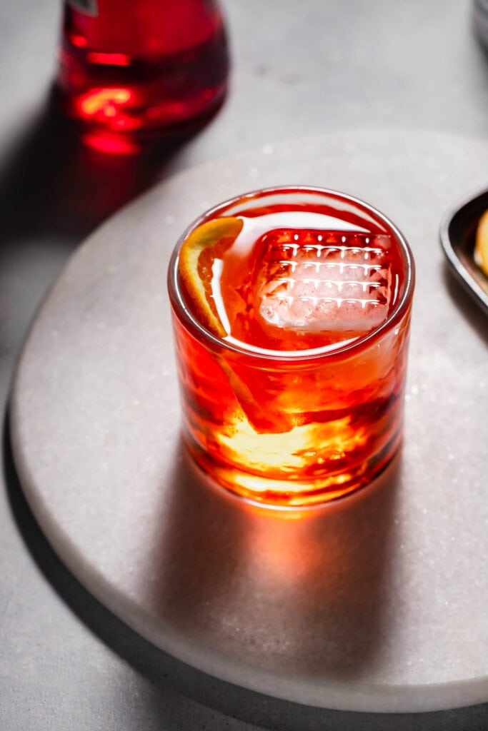 Aperol negroni with large ice cube in glass.