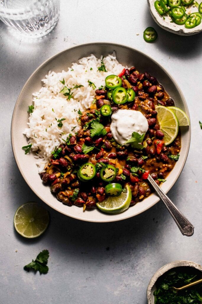 Curry served in bowl with sour cream and lime wedges.