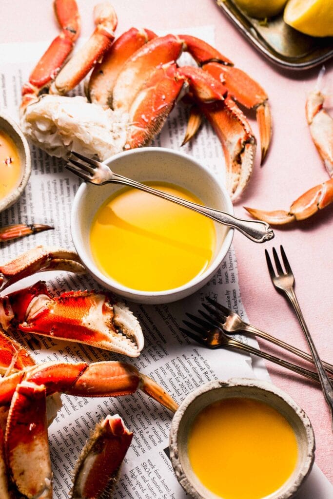 Crab feast arranged on table with bowls of butter. 