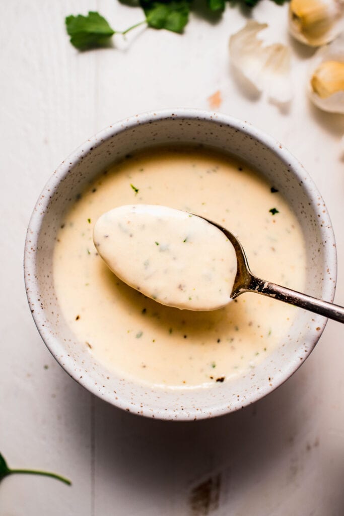 Spoonful of creamy garlic sauce.