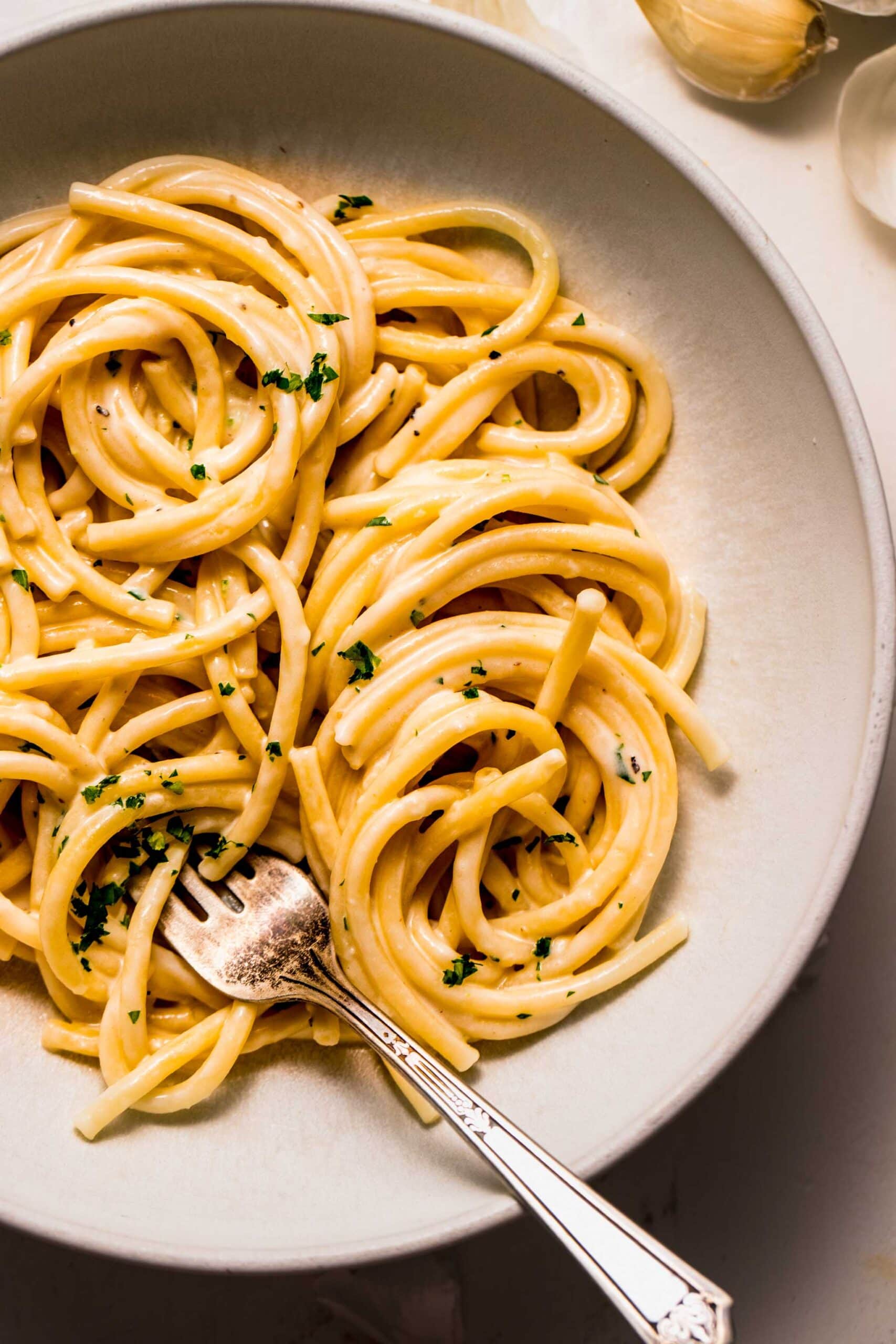 Pasta with creamy garlic sauce in bowl.