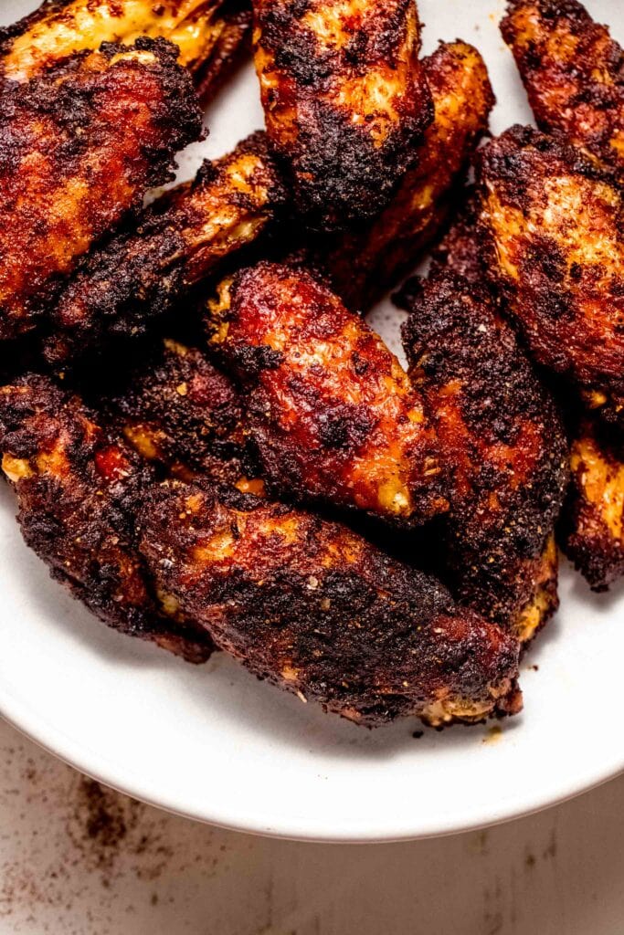 Close up of cooked wings coated in dry rub. 