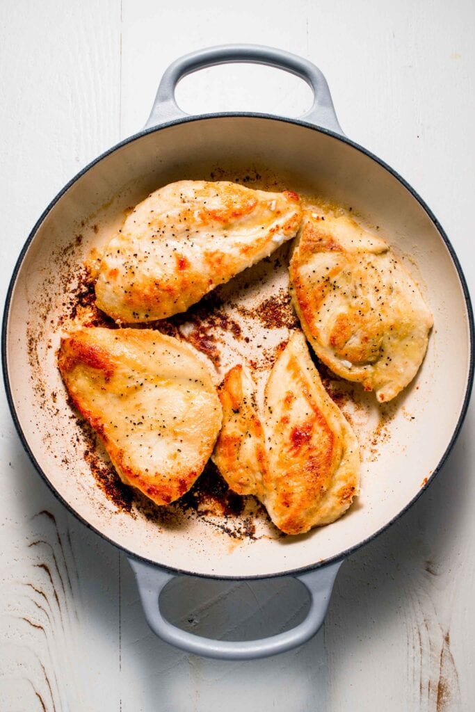 Pan fried chicken breasts in skillet. 