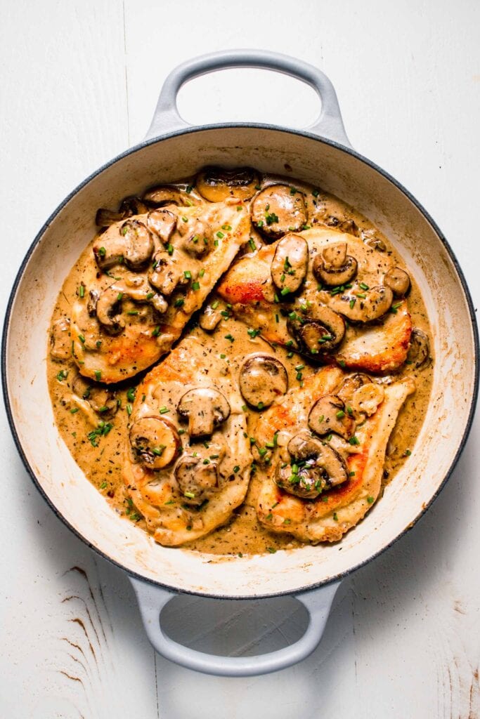 Chicken in skillet with mushroom cream sauce. 