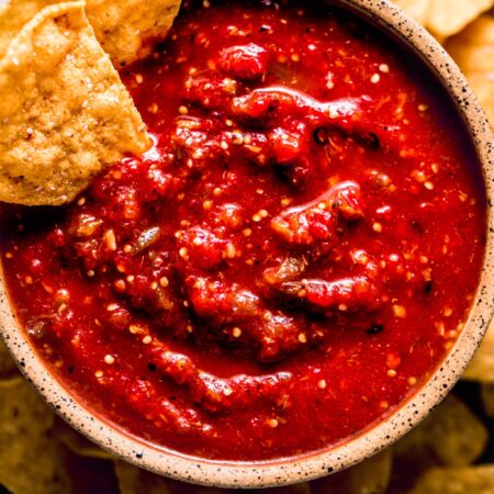 Chipotle hot salsa in bowl with chips dipped into it.