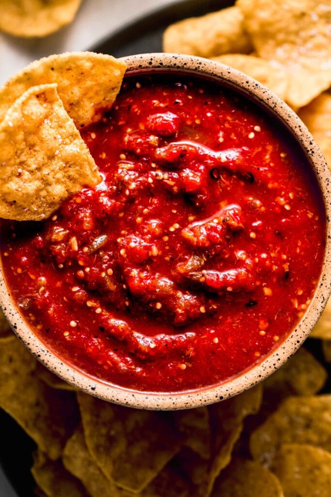 Chipotle hot salsa in bowl with chips dipped into it.