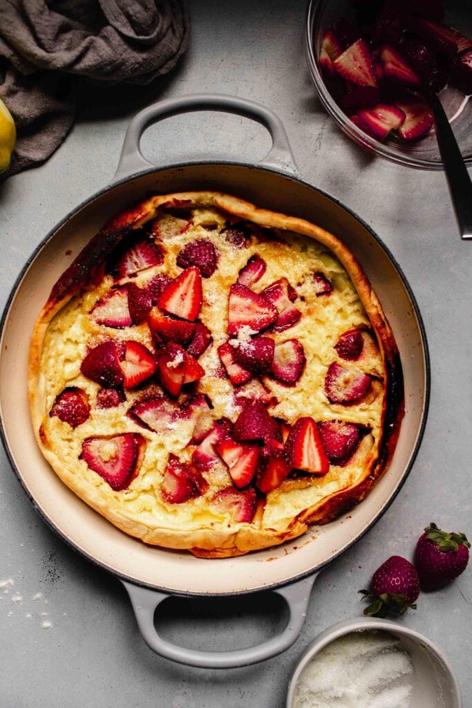 Overhead shot of strawberry dutch baby in skillet. 