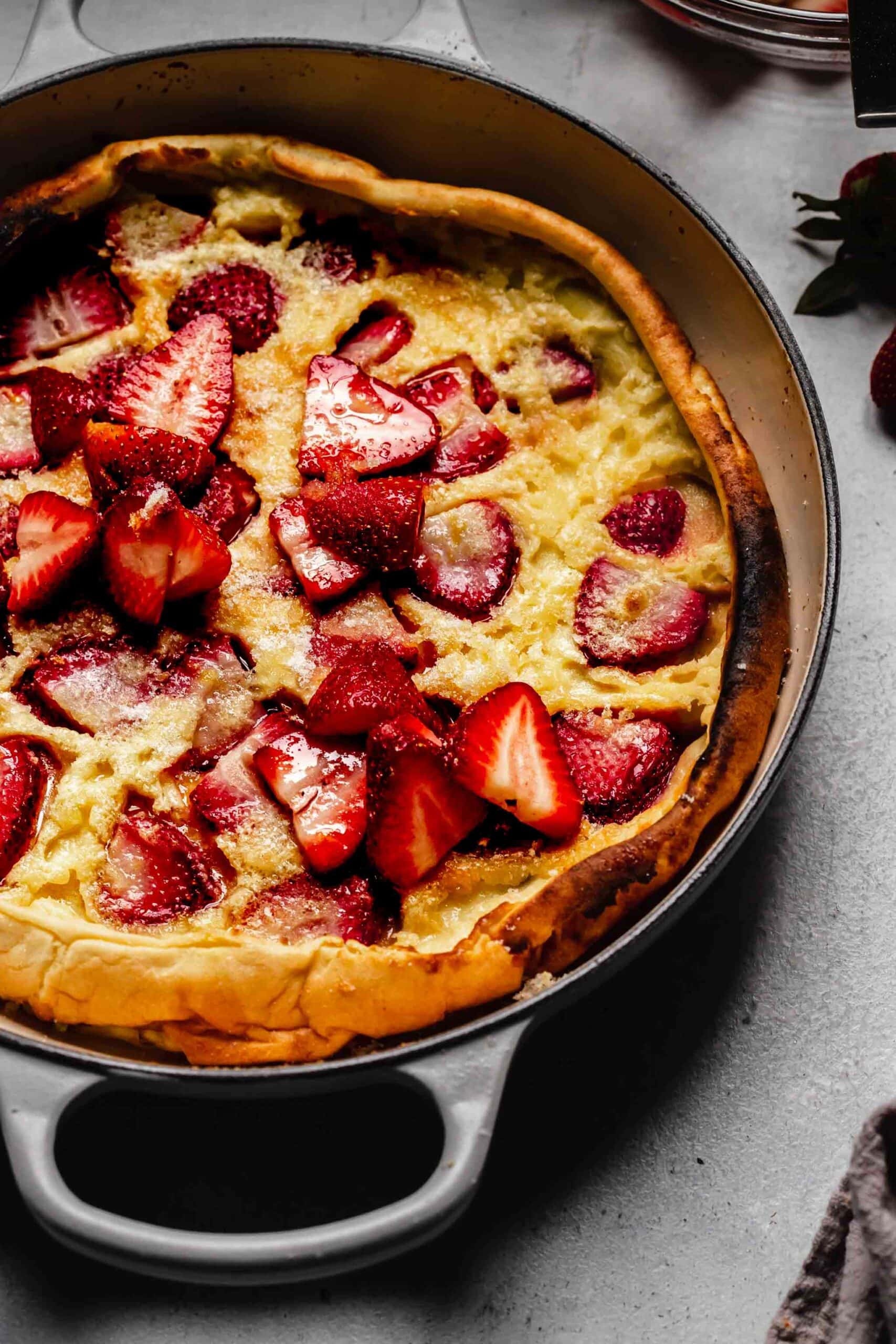 Side view of strawberry dutch baby in skillet.